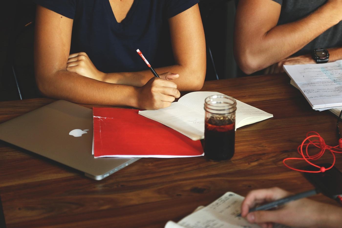 Notas, portátil e bebida numa mesa de reunião