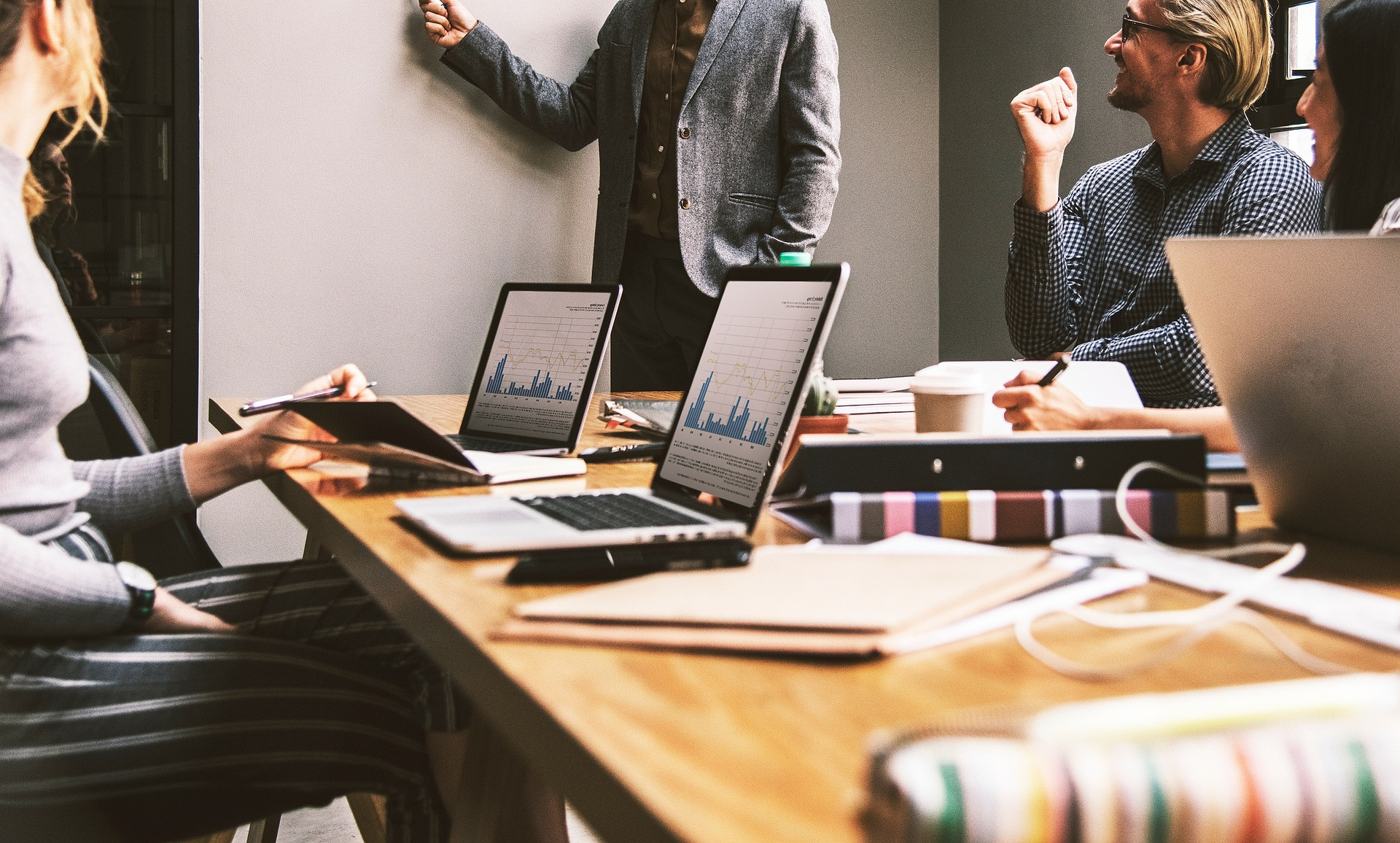 Equipa em reunião a analisar gráficos em portáteis